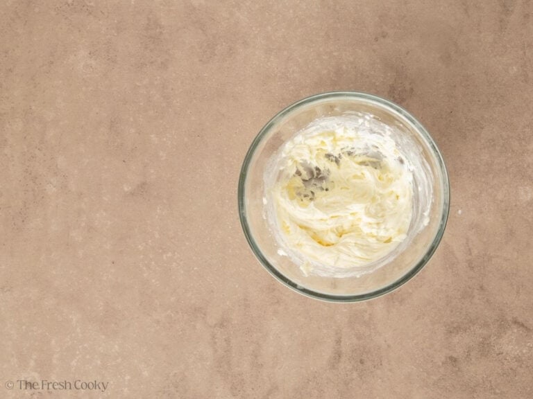 Smooth cream cheese glaze in glass bowl.