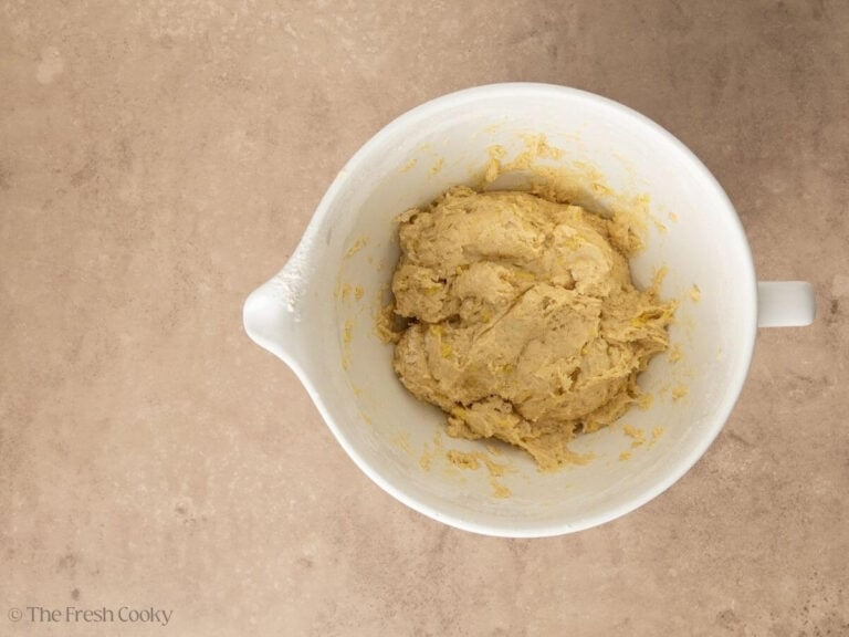 Shaggy dough before fully kneading, in white bowl.
