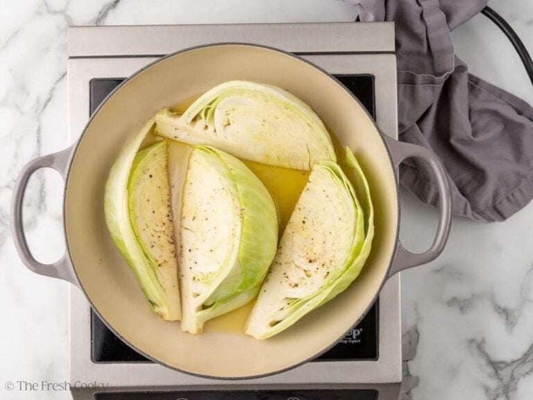 Cabbage wedges being seared in a cast iron.