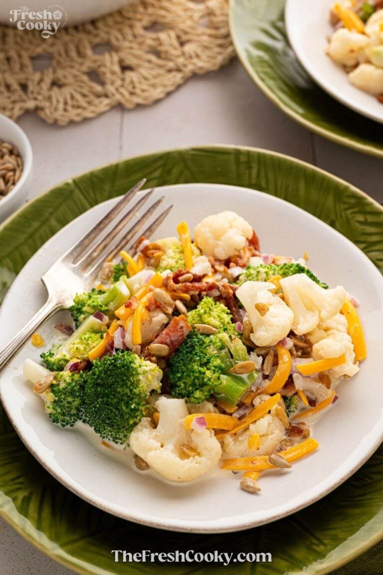 A serving of broccoli cauliflower salad on a pretty green plate, for pinning.