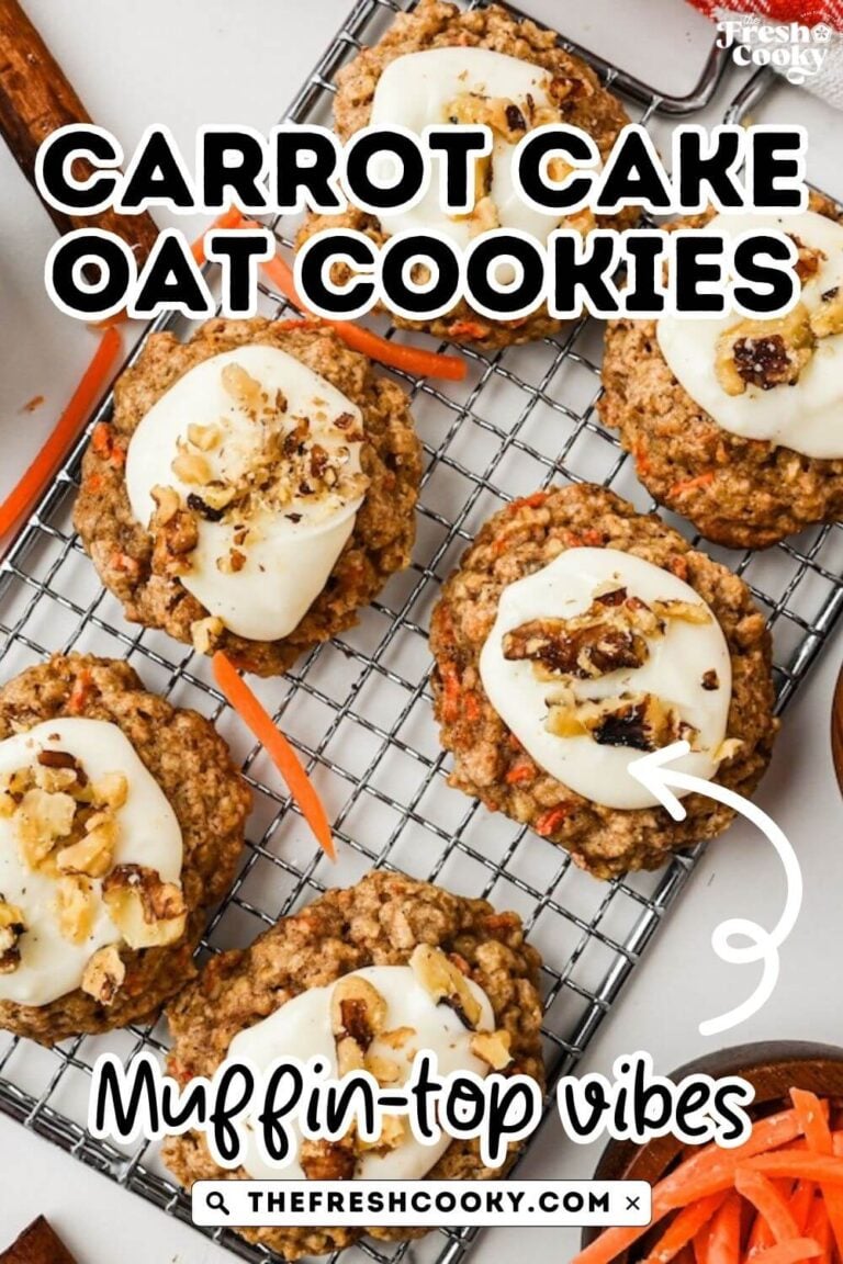 A wire cooling rack with frosted cookies on it, surrounded by shredded carrots.