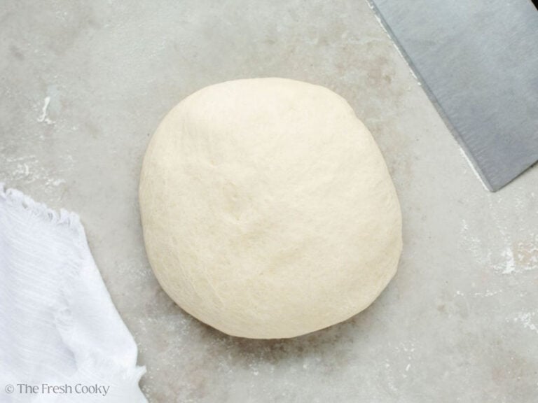 Bread dough round on parchment after going through cycle in bread machine.