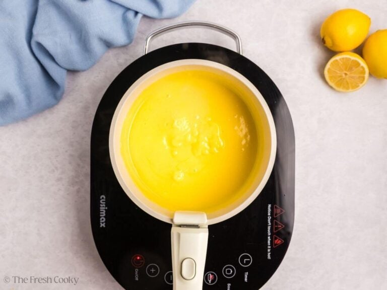 A small saucepan with lemon curd on a burner.