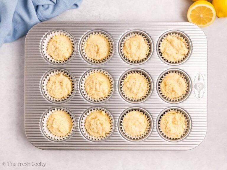 Lemon meringue cupcake batter scooped into liners.