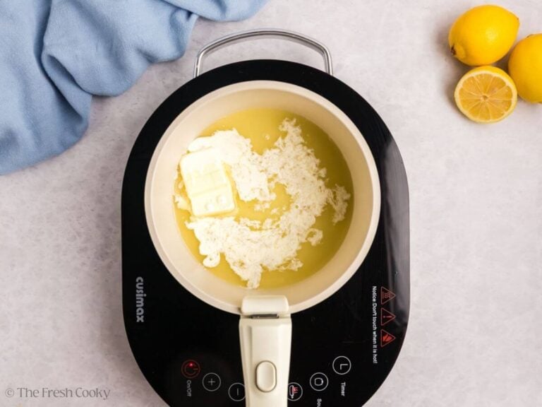 A small saucepan with melted butter on an induction burner.