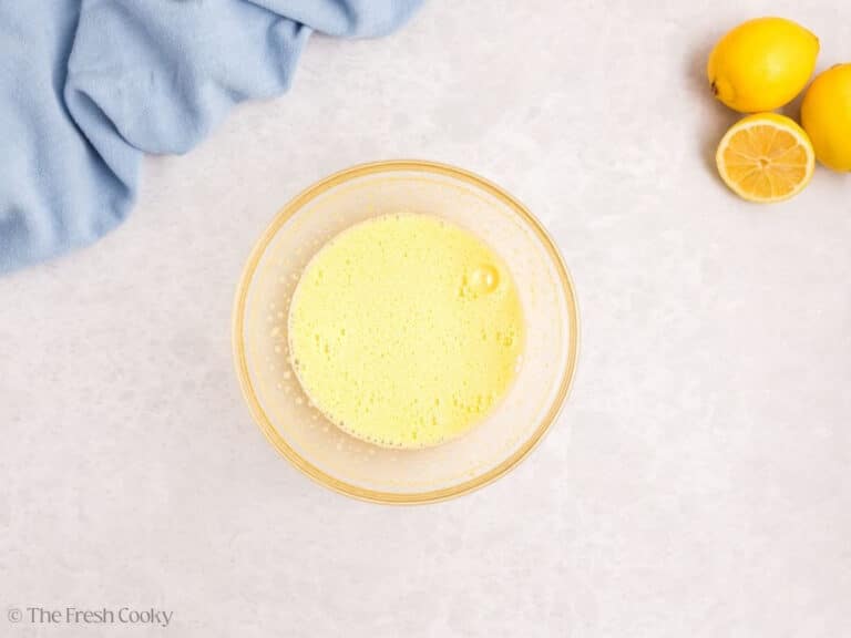 A glass bowl with melted butter and lemon juice.