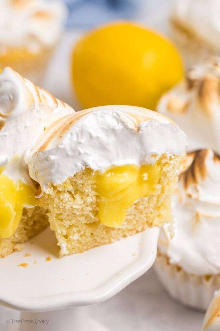 Lemon meringue cupcake cut open to reveal the center.