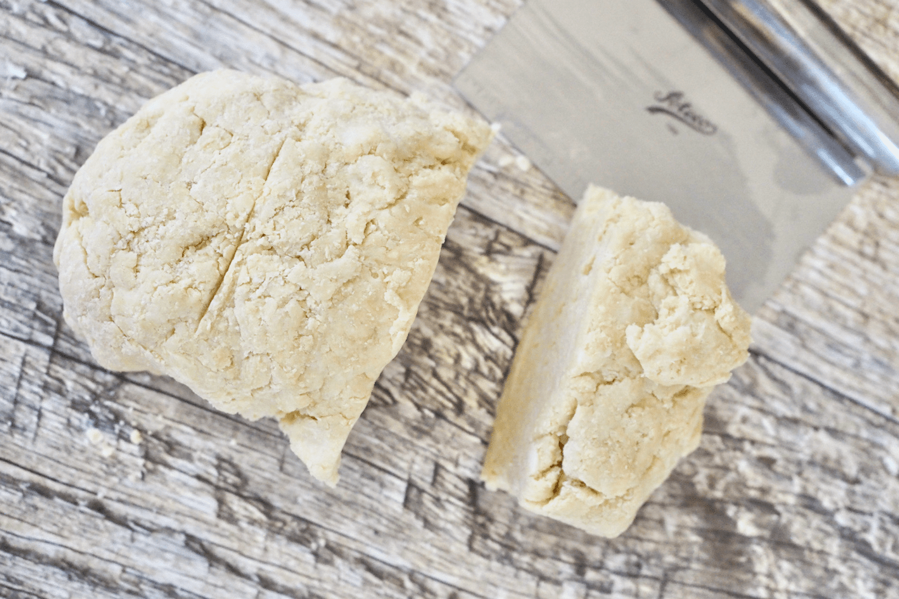 Dough split into two pieces, one larger than the other.