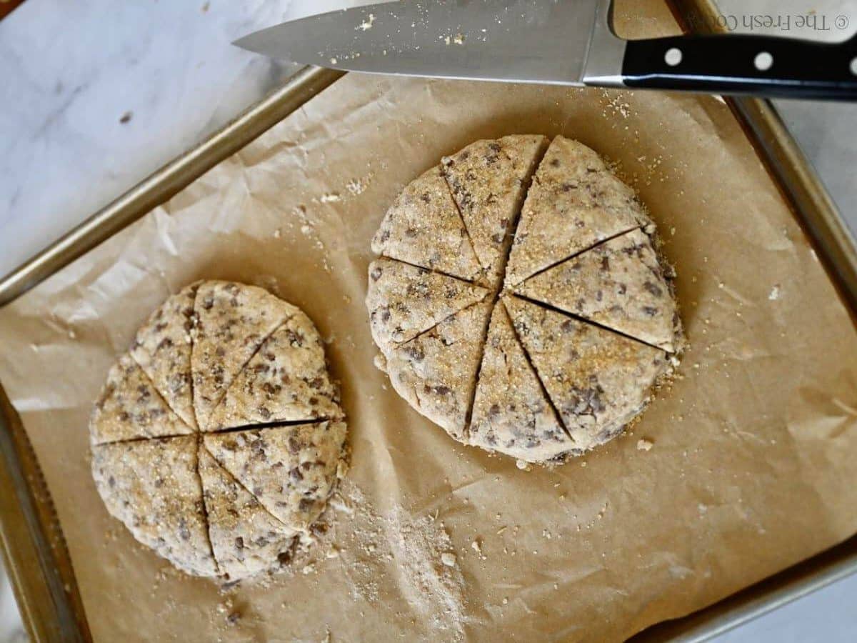 16 mini scones dough cut in two discs on a baking sheet.