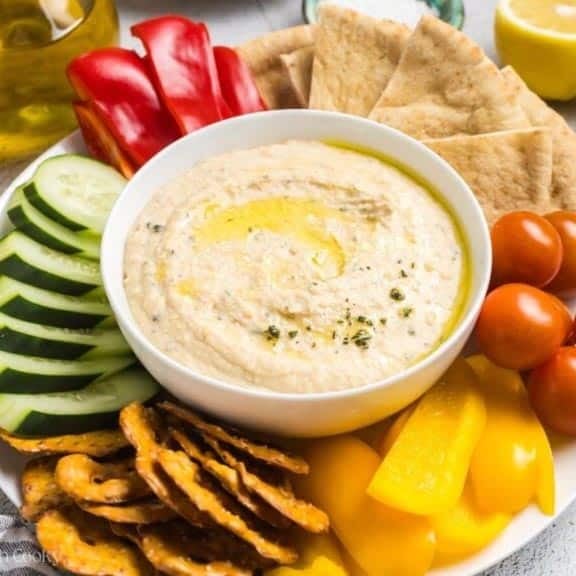 White bean dip surrounded by veggies and crackers