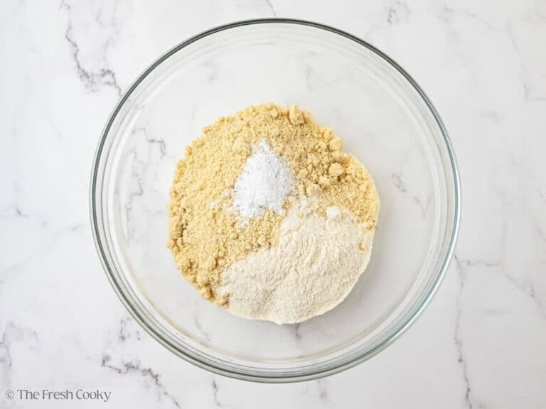 A glass bowl with dry ingredients for almond flour olive oil cake.