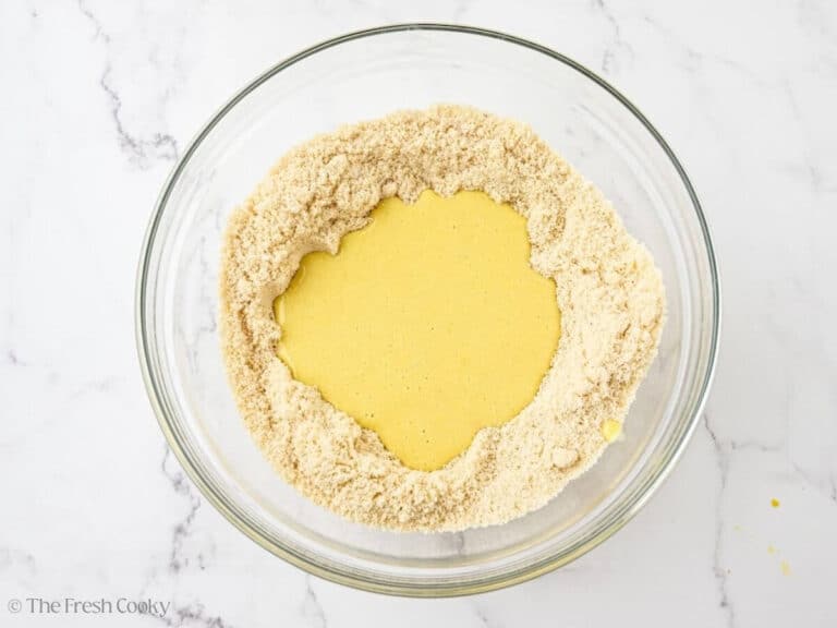 A glass bowl with almond flour and wet ingredients.