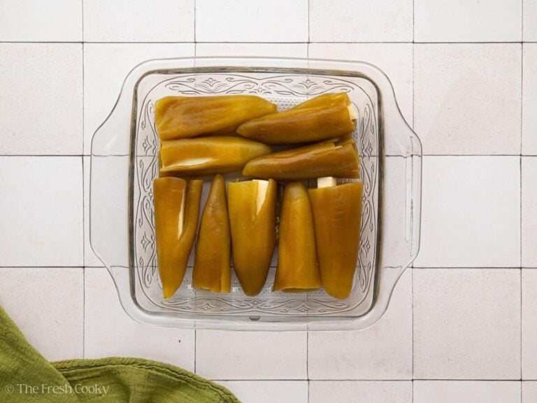 Chile rellenos stuffed with cheese in a 9x9 glass baking dish.