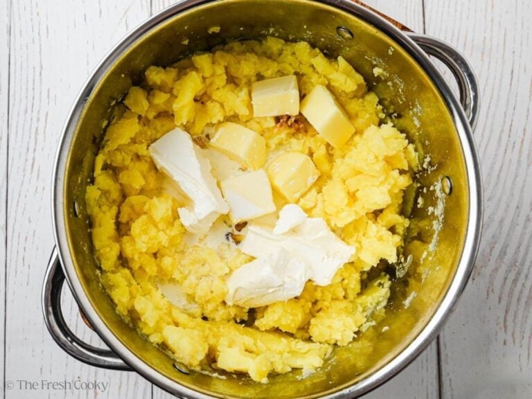 Cream cheese, roasted garlic, soft butter on top into mashed potatoes in stockpot.