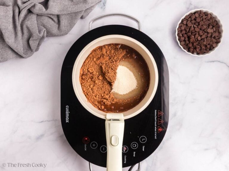 A white saucepan with chocolate ingredients for marble bundt cake.