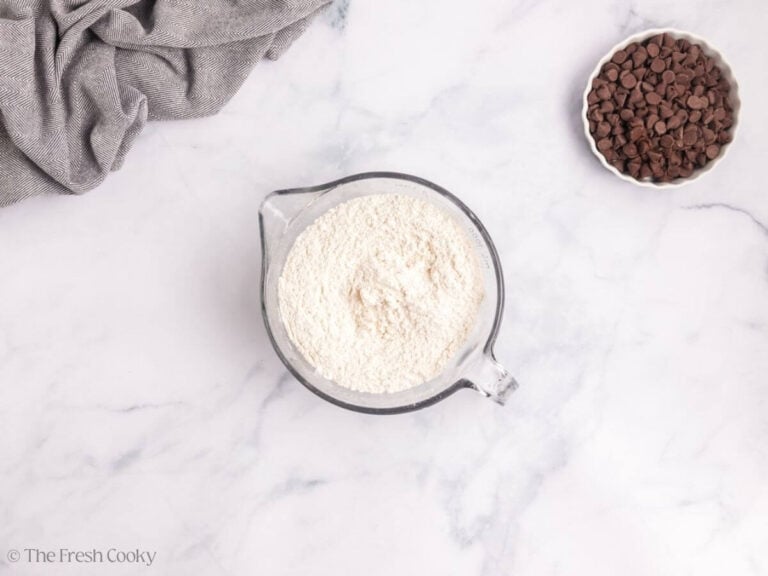 A large glass measuring cup with flour.