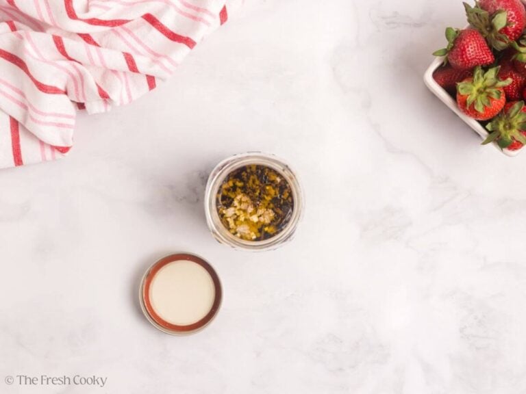 Ingredients for the dressing in a jar with a lid nearby.