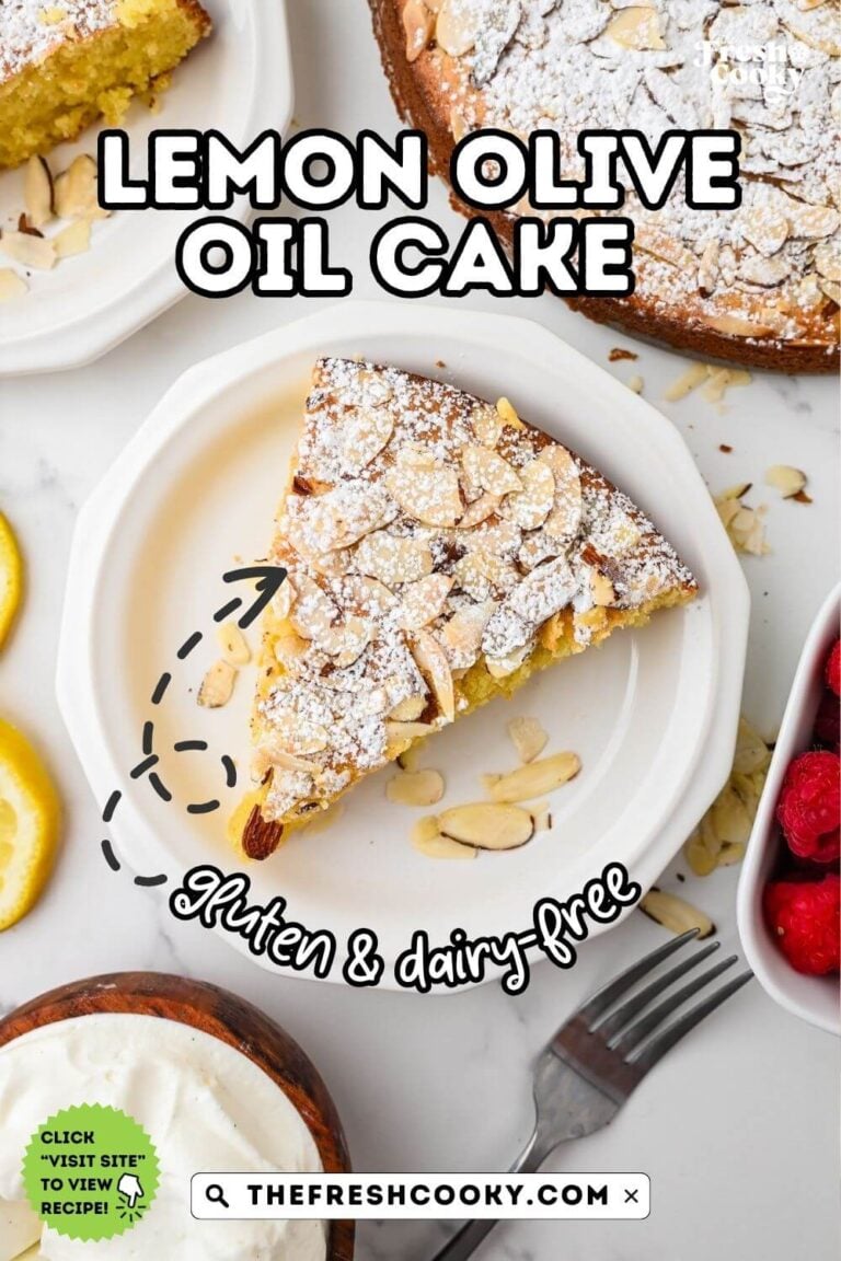 Olive oil cake slice on a pretty white plate, topped with lemon, sliced almonds and powdered sugar, to pin.