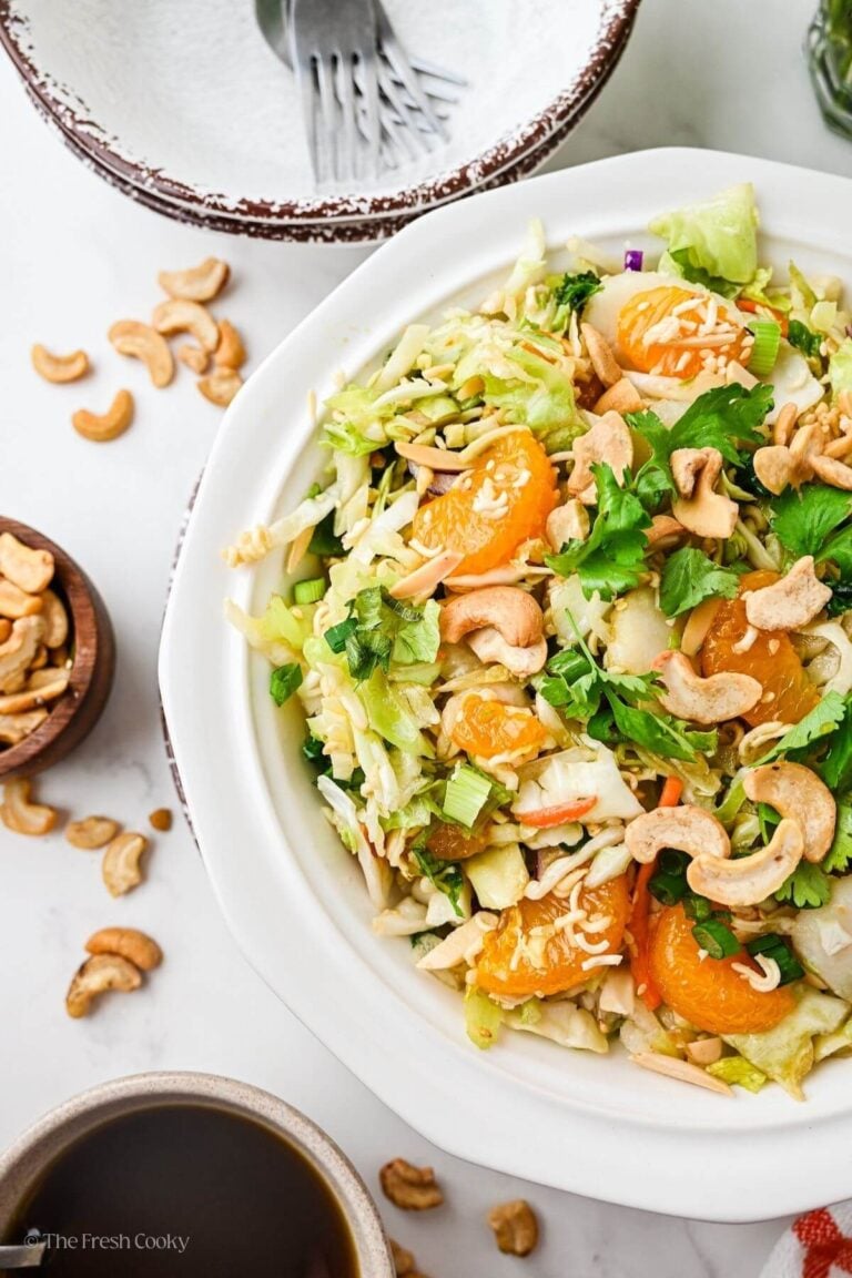 Asian ramen salad in pretty white plate topped with cashews.