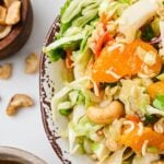 Close up of ramen noodle salad with cabbage, mandarin oranges, cashews, cilantros, tossed in a sweet Asian dressing.