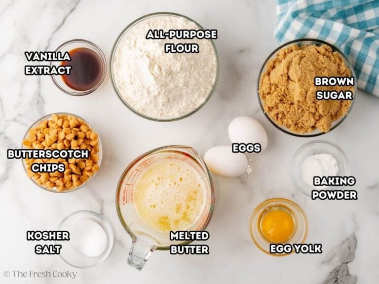 Labeled ingredients for blondies, L-R Butterscotch chips, vanilla extract, all purpose flour, brown sugar, baking powder, egg yolk and eggs, melted butter, and kosher salt.