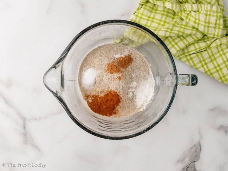 A large glass measuring cup with dry ingredients for buckwheat pancakes.