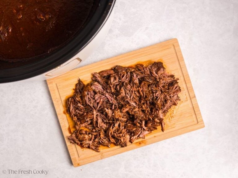 Shredded birria beef on a cutting board.