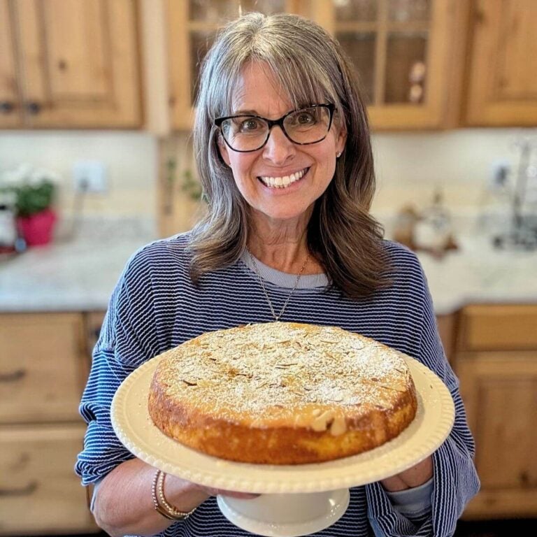 The Fresh Cooky, Kathleen holding a pedestal with olive oil cake on top.