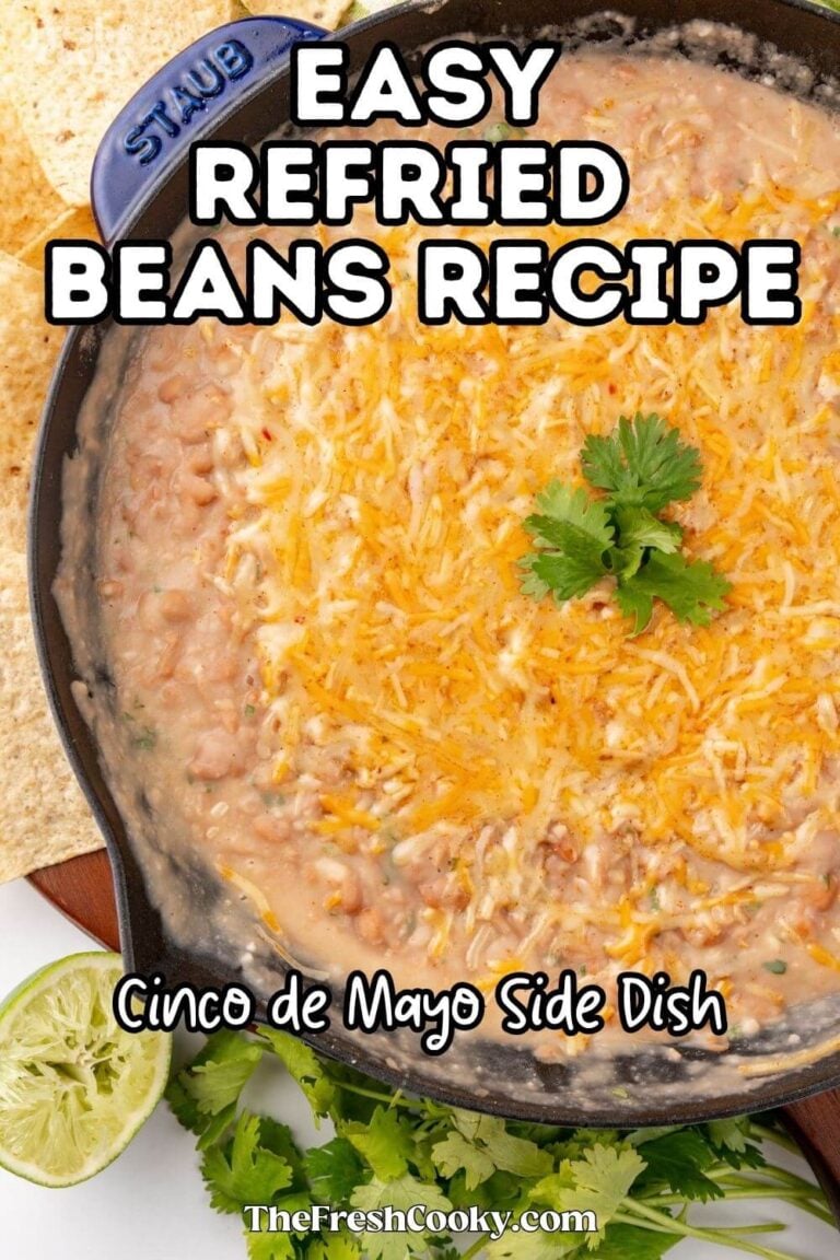 A cast iron pan filled with creamy, refried beans and topped with melted cheese and cilantro. To pin.