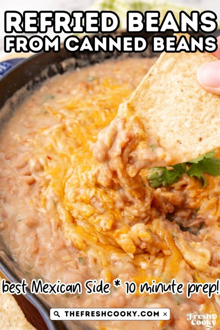 Pin showing a cast iron skillet filled with cheesy refried beans and hand dipping tortilla chip in.