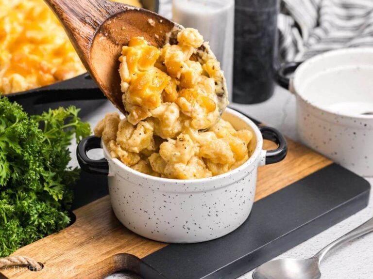 Spooning mac and cheese into a bowl.