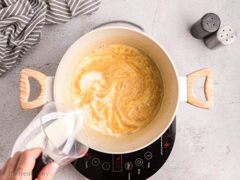 Pour milk and half and half into the roux.