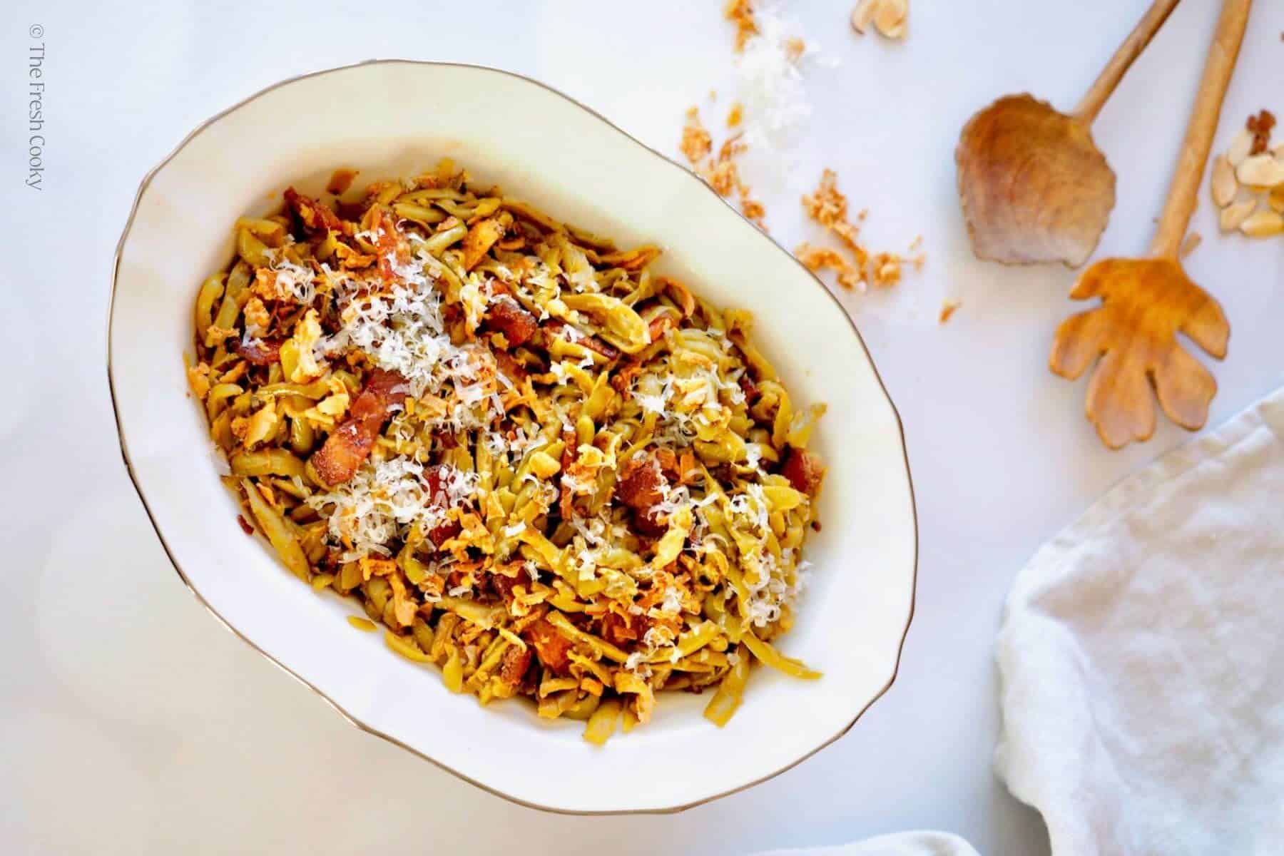 Image of top down shot of canned green beans recipe with pretty wooden serving spoon and crispy fried onions.