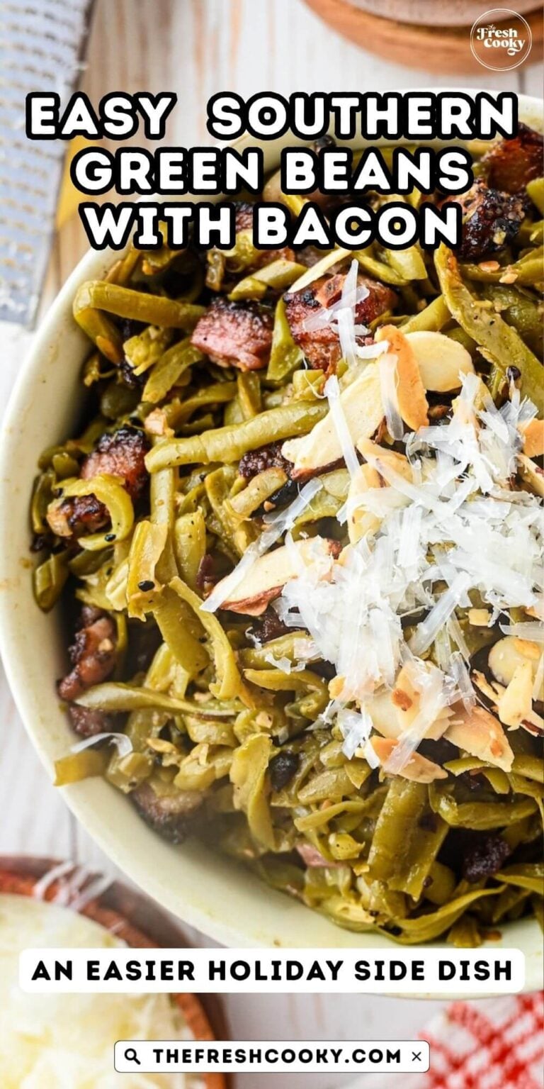Close-up of a bowl of French style green beans, with crispy bacon, topped with grated parmesan cheese and toasted almonds, for pinning.