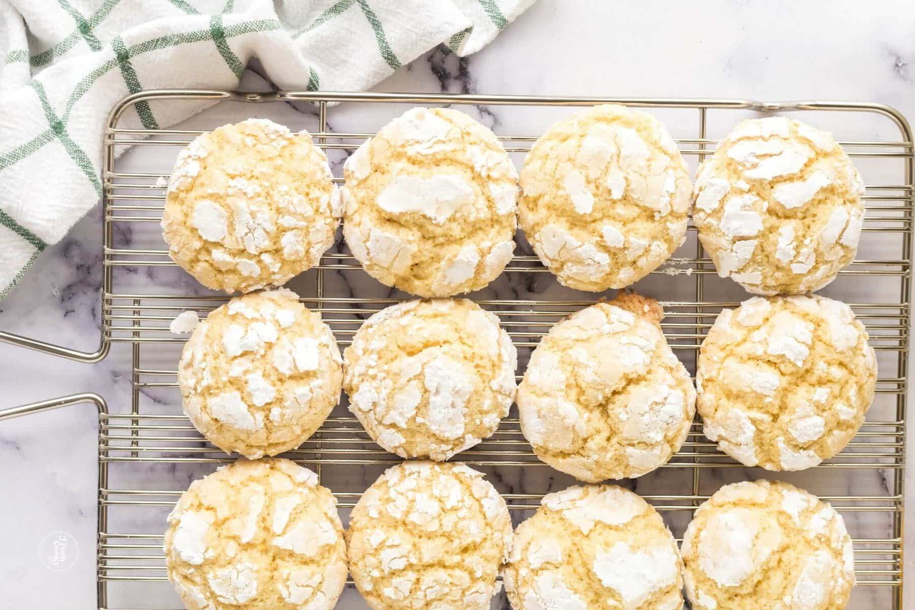 Lemon crinkle cookies on a cooling rack, with a tea towel.