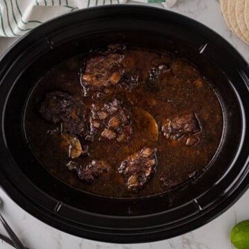 Simmered and slow cooked barbacoa beef in crockpot.