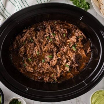 Barbacoa beef back in sauce in crockpot.
