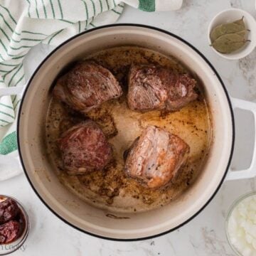 Browned and seared chuck post in chunks in dutch oven.