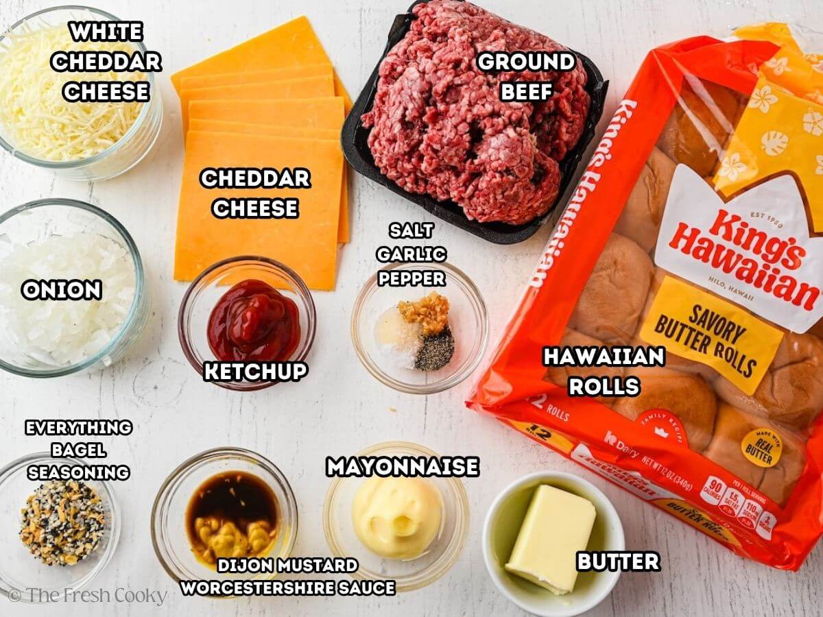 Labeled ingredients for cheeseburger sliders, L-R white cheddar cheese, cheddar cheese, ground beef, King's Hawaiian rolls, butter, mayonnaise, Dijon, Worcestershire, onion, ketchup, salt, garlic and pepper.