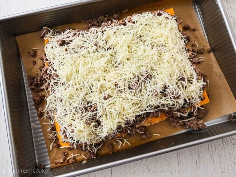 Sprinkle shredded white cheddar on top of ground beef.