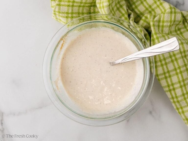 Creamy sherried dressing for chicken salad with grapes in bowl with spoon.