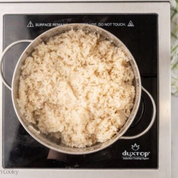 Overhead shot of rice cooking in a large pot.