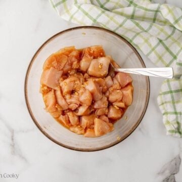 Chicken mixed together with the marinade in a large bowl.