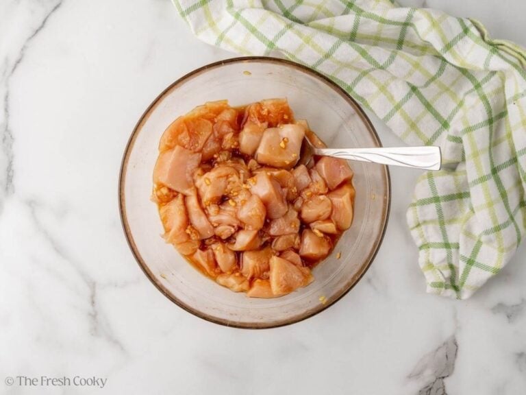 Chicken mixed together with the marinade in a large bowl.