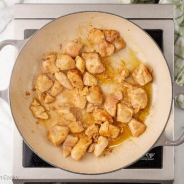 Seared teriyaki chicken pieces in a skillet.