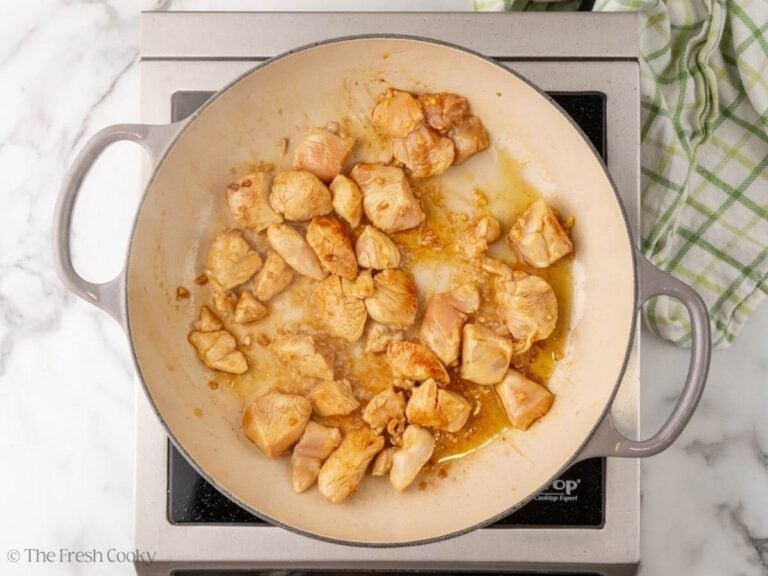 Seared teriyaki chicken pieces in a skillet.