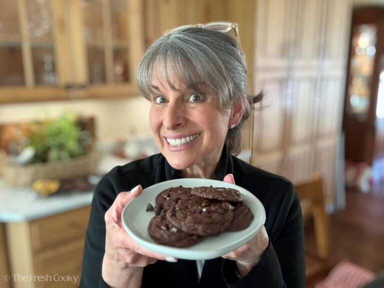 Kathleen, author of the Fresh Cooky, holding a plate of chocolate banana cookies.