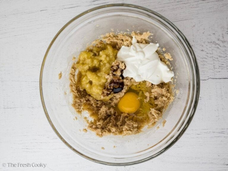 Eggs, banana, sour cream and vanilla added to the butter and sugar mixture in a bowl.