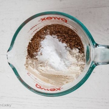Flour, cocoa powder, baking soda and baking powder measured into a bowl.