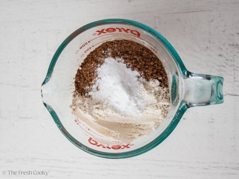 Flour, cocoa powder, baking soda and baking powder measured into a bowl.